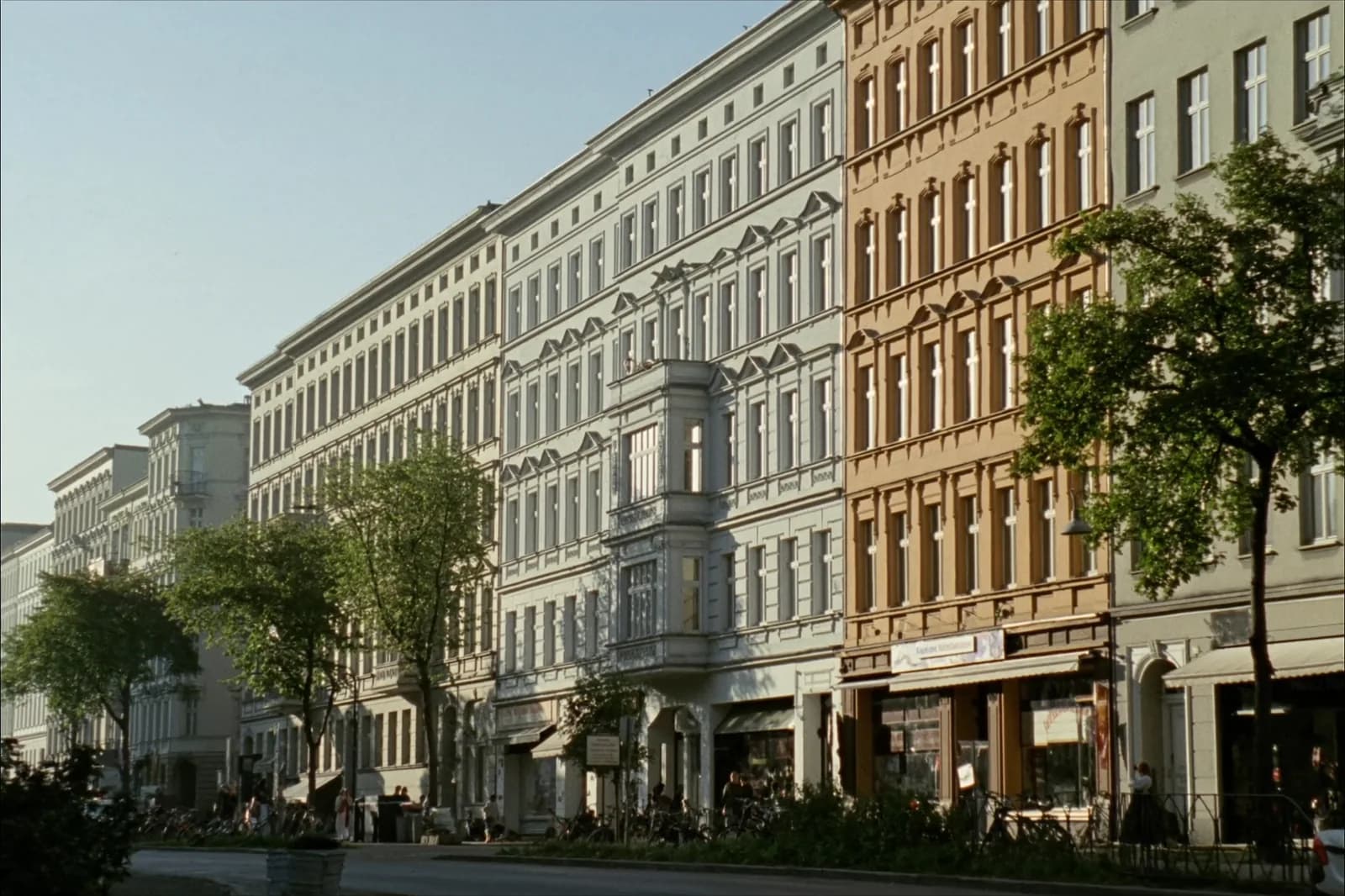 Berliner Altbauzeile mit Ladengeschäften und Straßenbäumen im Bezirk Wedding.
